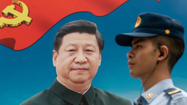 A member of the People's Liberation Army (PLA) stands guard in front of a billboard of Chinese President Xi Jinping. Picture: Getty Images.