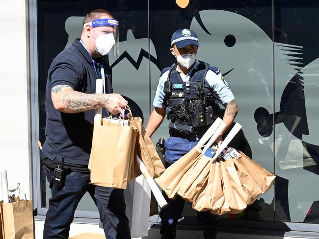 SYDNEY, AUSTRALIA - NewsWire Photos SEPTEMBER 8, 2021: Police help volunteers and support workers  carry donated games and food supplied by Northern Beaches residents to the Common Ground apartment building which is in Lockdown.Picture: NCA NewsWire / Jeremy Piper