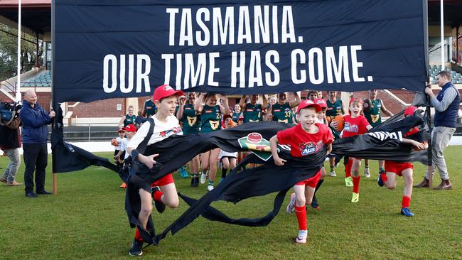 HOBART, AUSTRALIA - MAY 03: Junior Tasmanian players run though a banner during the AFL Tasmanian Team Announcement at North Hobart Oval on May 03, 2023 in Hobart, Australia. (Photo by Michael Willson/AFL Photos via Getty Images)