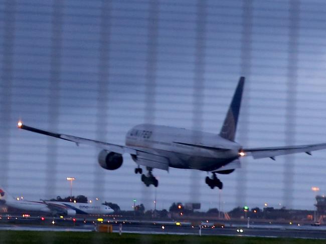Airport A plane lands at Sydney airport as another rain band hits