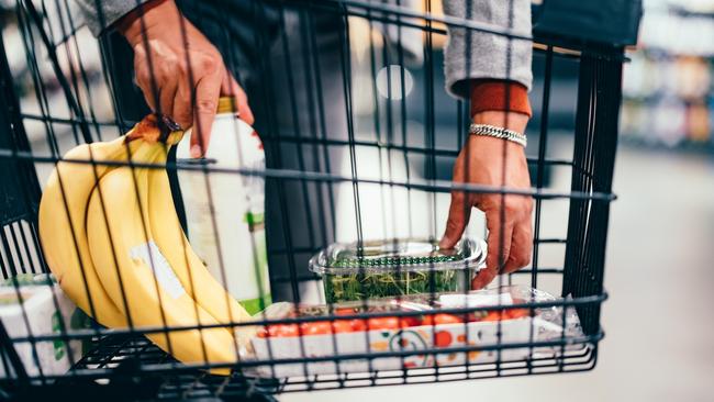 Close up of an unrecognizable man putting groceries into a shopping cart in the supermarket.  Picture: istock