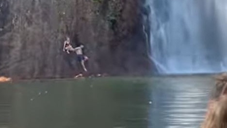 The couple were forced to cling to rocks in order to get out of the croc-infested waters.