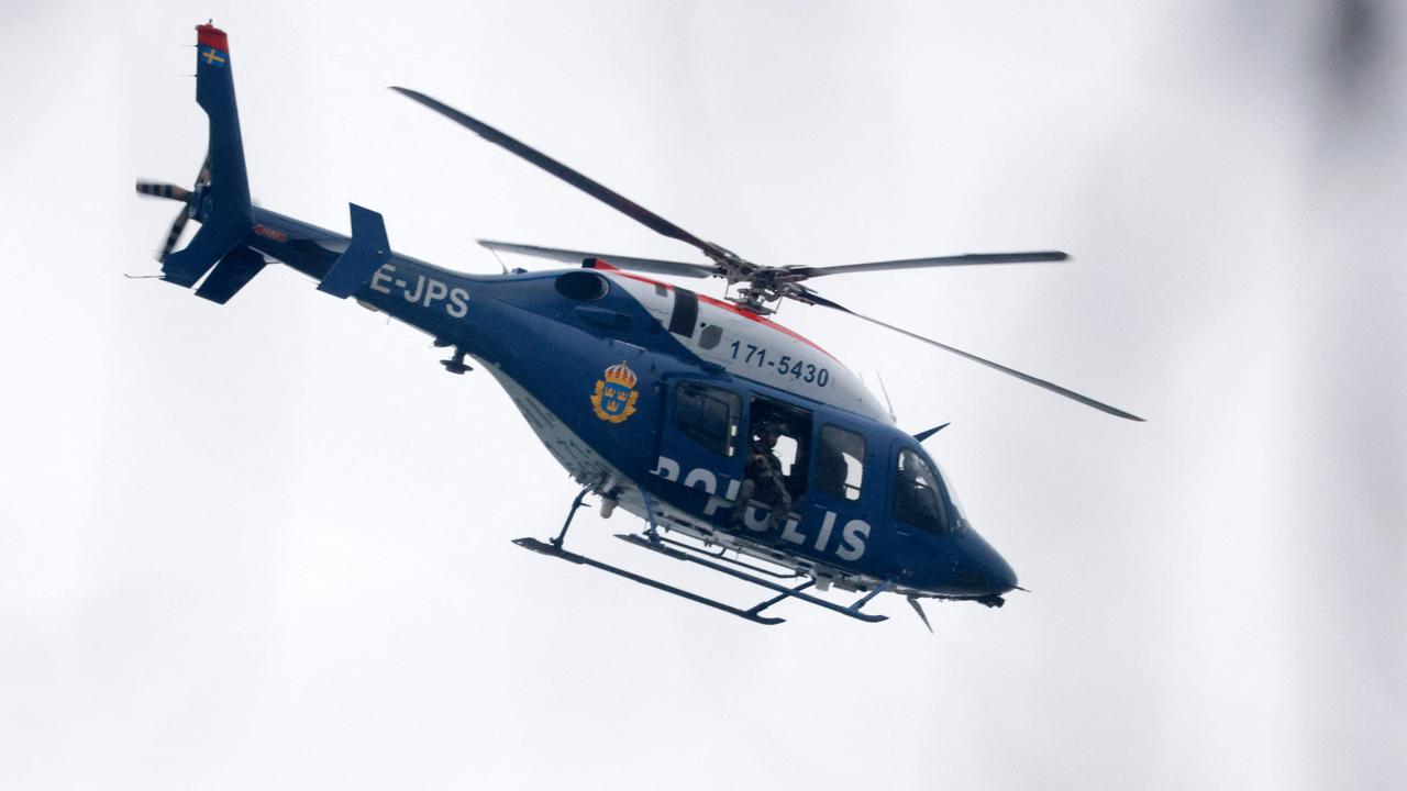 A police helicopter flies over the sky at the Risbergska School in Orebro, Sweden. (Photo by Kicki NILSSON / TT NEWS AGENCY / AFP)