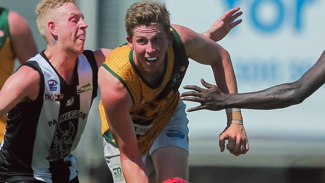 Leroy Larson get set to handball while under pressure from a Palmerston opponent. Picture: GLENN CAMPBELL