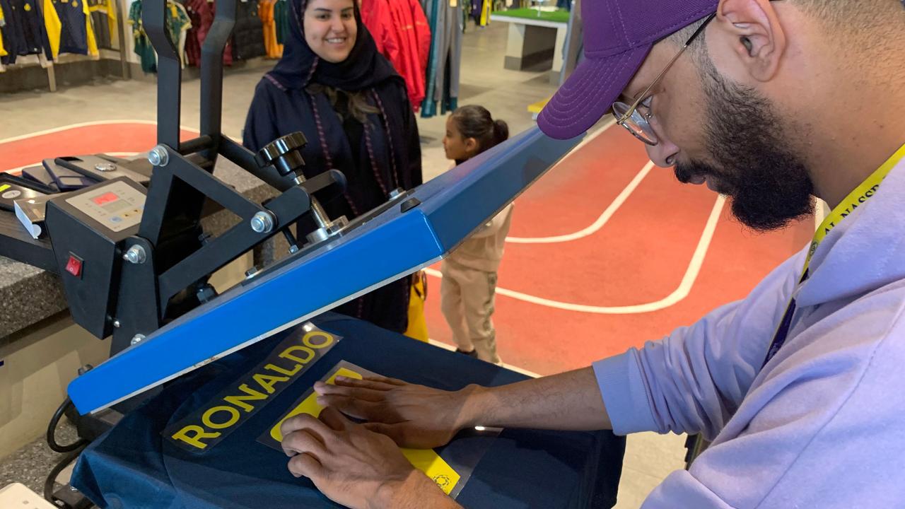 An employee at the Saudi Al Nassr FC shop prepares a t-shirt marked Ronaldo and number 7, in the Saudi capital Riyadh, on December 31, 2022. (Photo by Fayez Nureldine / AFP)