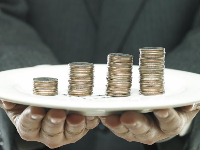 CAREERS: business concept/a businessman's hand holding a coin tower on a dish