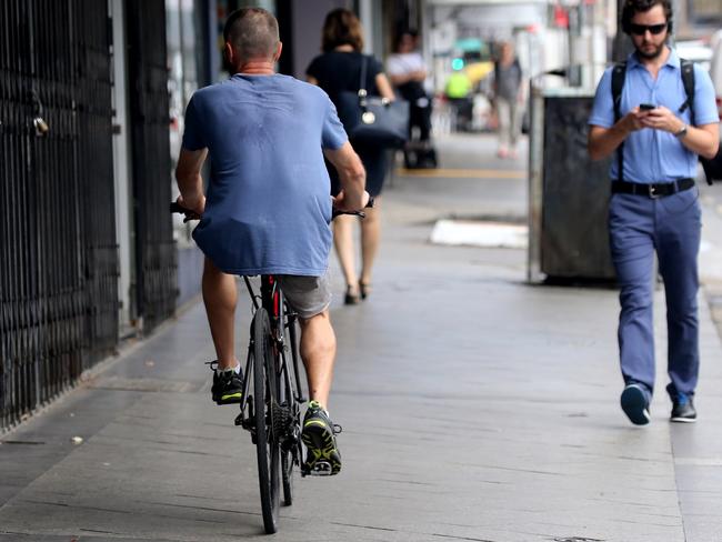 A bike rider without a helmet riding along a footpath today. Picture: John Grainger