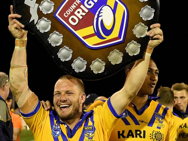 Nathan Ross holds the shield aloft after their win over Country.