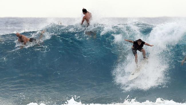 Surfers are seen at Snapper Rocks on the Gold Coast, Thursday February 21, 2019. Huge swells and high tides are set to pummelling southeast Queensland beaches over the coming days as Cyclone Oma tracks towards the Queensland coast. (AAP Image/Dave Hunt)