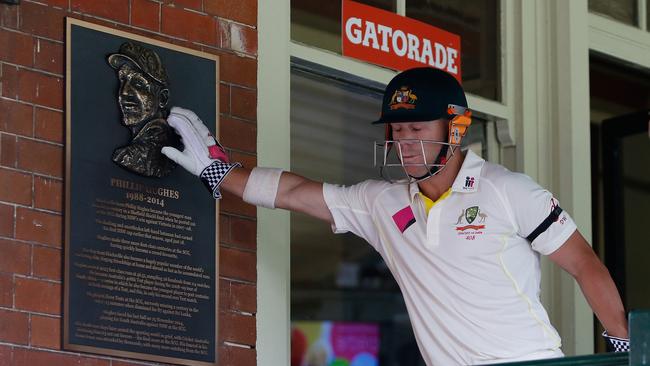 David Warner touches the plaque dedicated to Phil Hughes. Picture: Daniel Munoz/Getty