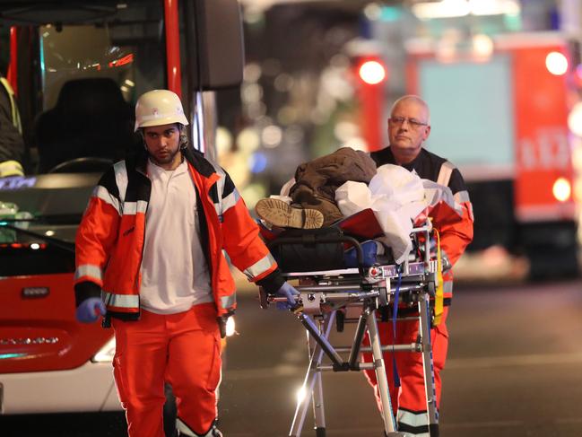 Rescue workers push a person on a stretcher in the area after a lorry truck ploughed through a Christmas market on December 19, 2016 in Berlin, Germany. Picture: Getty
