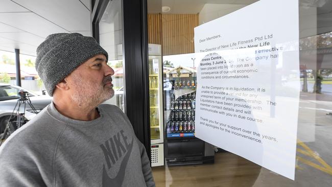 Michael Piovesan reads the closure notice on the front door of New Life Fitness at Woodville. Picture: NewsWire / Roy VanDerVegt