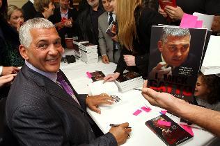 Mick Gatto signs books for a crowd of guests. Picture: David Caird