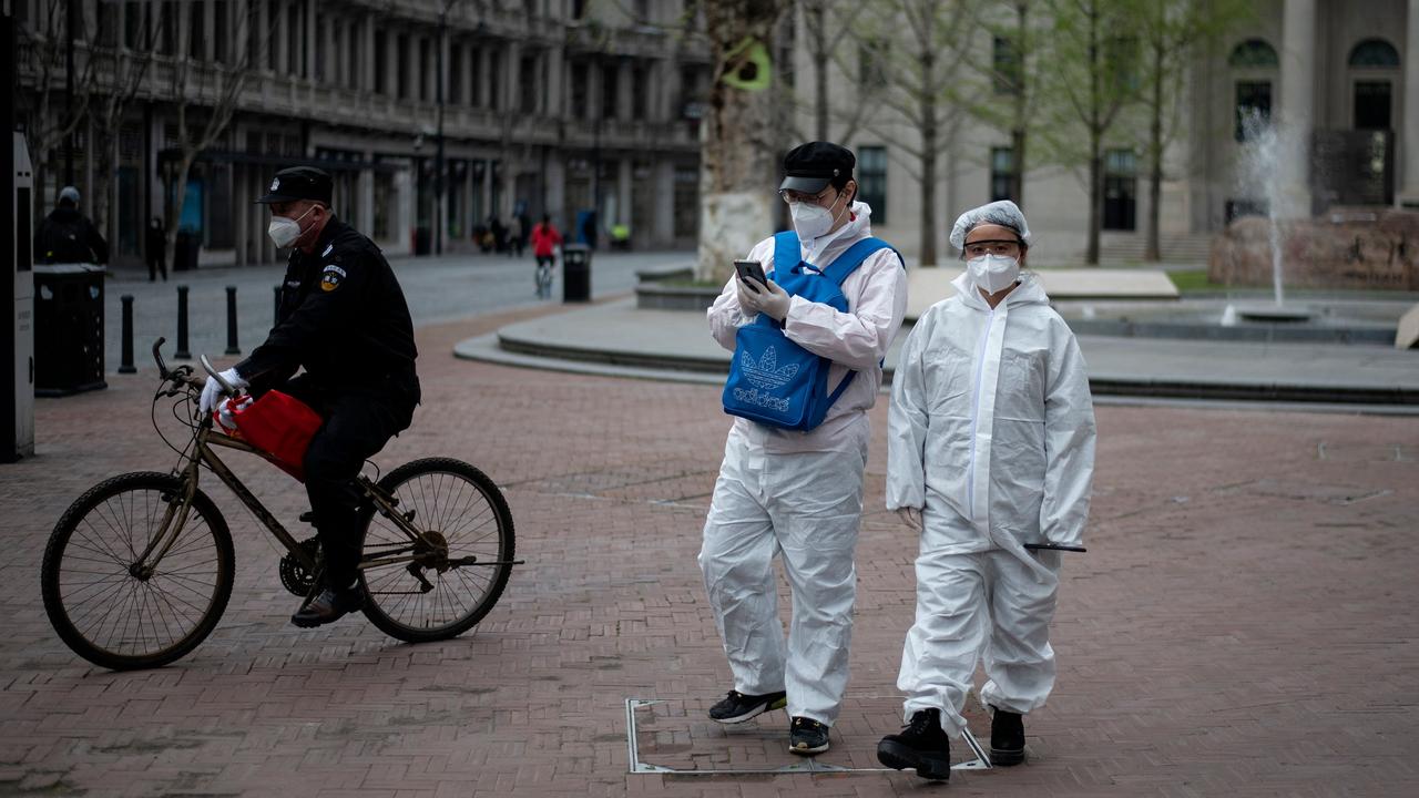 People wearing hazmat suits as a preventive measure against the COVID-19 coronavirus walk along a street in Wuhan, in China's central Hubei province on April 1, 2020. Picture: Noel Celis/AFP