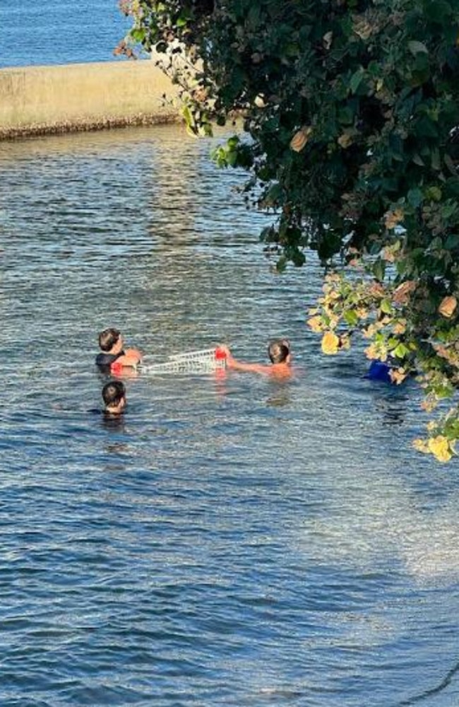 Locals digging trolleys out of Noosa river. Picture – contributed.