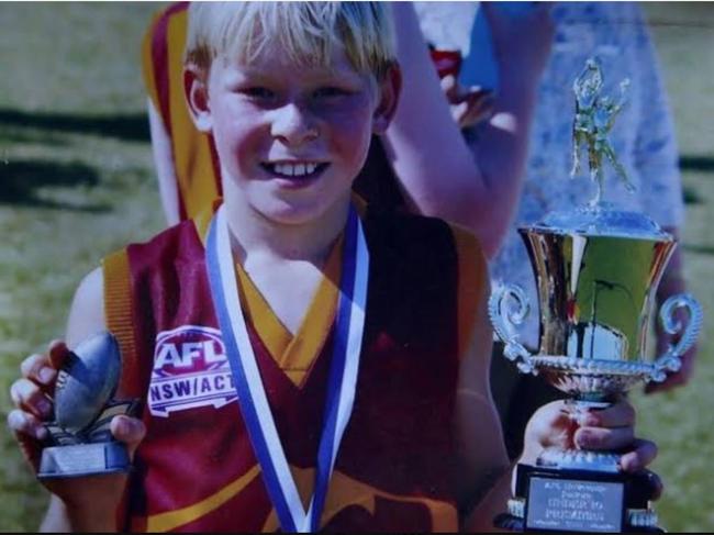 A young Isaac Heeney with some of his awards from playing with Cardiff Hawks.