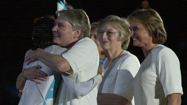 Australian sportswomen Shane Gould, Shirley Strickland, Dawn Fraser and Debbie Flintoff-King smile as Raelene Boyle hugs cauldron lighter, Cathy Freeman, at the opening ceremony of the 2000 Sydney Olympic Games. Picture: News Corp