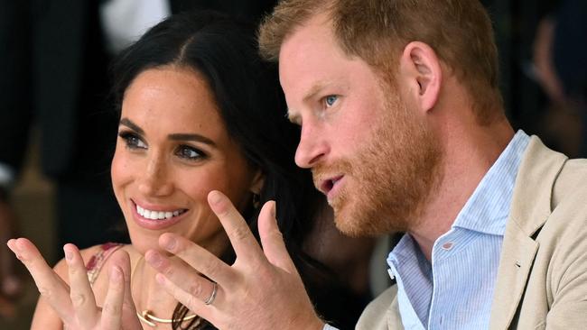 Britain's Prince Harry (R), Duke of Sussex, speaks with his wife Meghan Markle while attending a show during a visit to the National Centre for the Arts in Bogota on August 15, 2024. Prince Harry and his wife, American actress Meghan Markle, arrived in Colombia at the invitation of vice President Francia Marquez, with whom they will attend various meetings with women and young people to reject discrimination and cyberbullying. (Photo by RAUL ARBOLEDA / AFP)