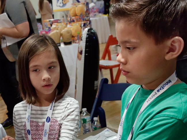 In this Oct. 1, 2014 photo Evan and Jillian, no last name given, of EvanTubeHD, try NBA Heros, by Jazwares, at the TTPM Holiday Showcase, in New York. Evan has over 800 million views on EvanTubeHD, where he reviews toys. (AP Photo/Richard Drew)