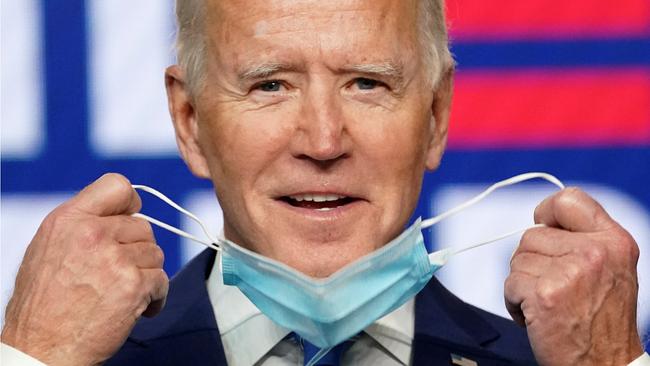 Joe Biden smiles as he pulls off his face mask to speak about the results of the 2020 US presidential election on Thursday.