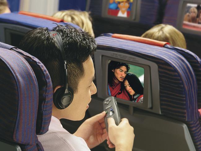 JULY 2001 : Economy class passenger watching inflight entertainment on Qantas Airlines flight, 07/01. Aviation / Aircraft / Interior Travel