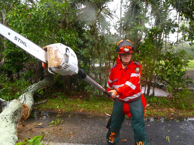 SES volunteer George Dellicompagni clears a fallen tree branch from Port Douglas Road. Picture: Peter Carruthers