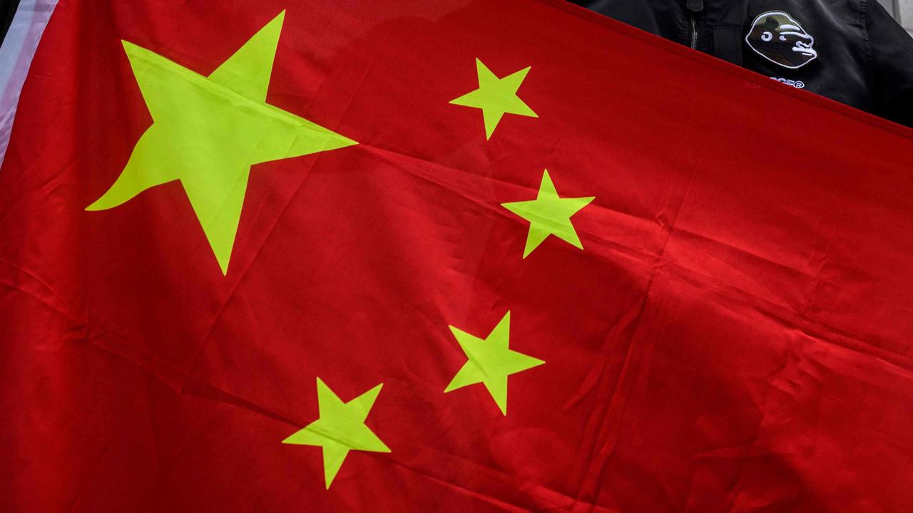 An man holds the national flag of China after a pro-Beijing activist group gathered outside the British Consulate-General to protest against the use of the British National (Overseas) passport in Hong Kong on February 1, 2021, as a new visa scheme offering millions of Hong Kongers a pathway to British citizenship went live the day before. (Photo by Anthony WALLACE / AFP)