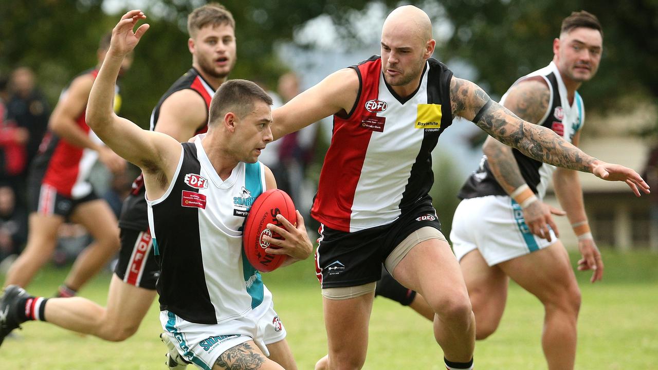 Essendon District: Josh Trembearth of Hillside tries to escape West Coburg’s Luke Baniowski. Picture: Hamish Blair