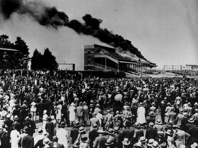 Caulfield racegoers watch in amazement as their grandstand burns down in 1922, the fire believed to have been started by Squizzy Taylor.