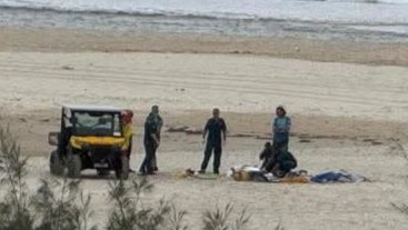 Paramedics and life savers treating a man in his sixties at Kirra Beach on Saturday morning after the skydiver broke his ankle upon landing. Picture: Facebook