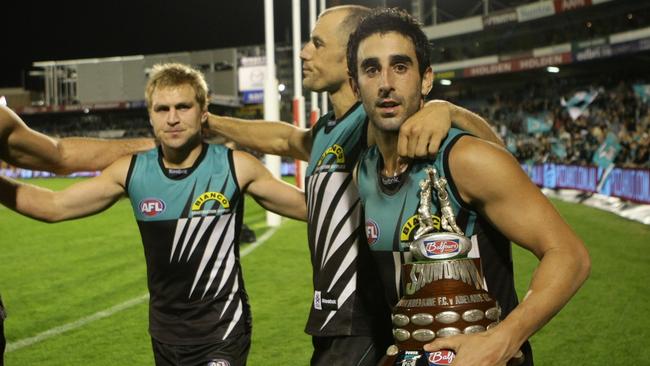 Kane Cornes, Warren Tredrea and Dom Cassisi celebrate with the old trophy after winning Showdown 26