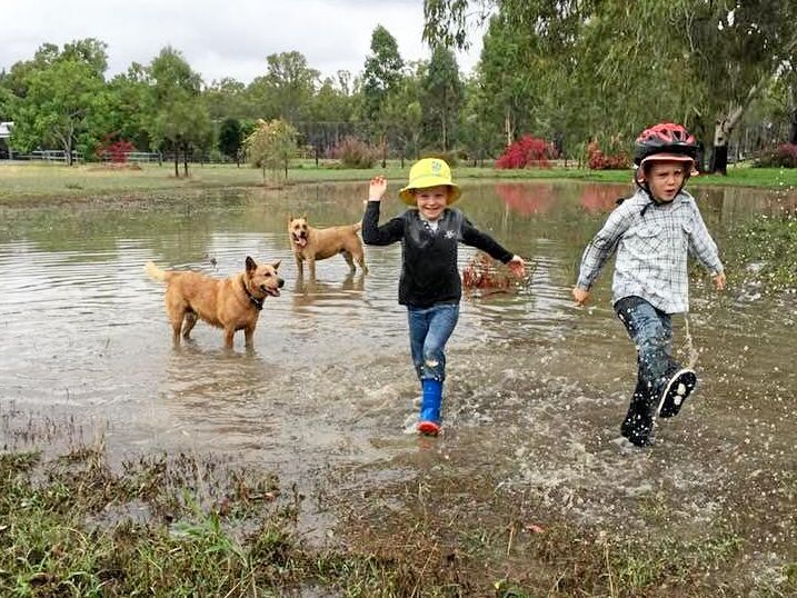 Wylie and Sidney Leo playing in the rain on Saturday at their place outside of Moura. They received 120mm for the week. Picture: Contributed