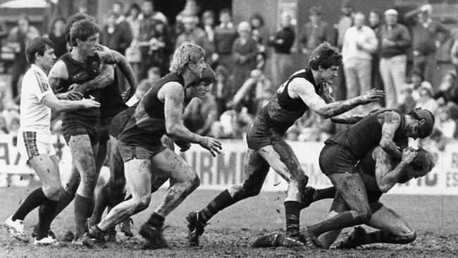 Sturt star Rick Davies pours a drink for Glenelg veteran Graham Cornes after State training. Both players will reach personal...