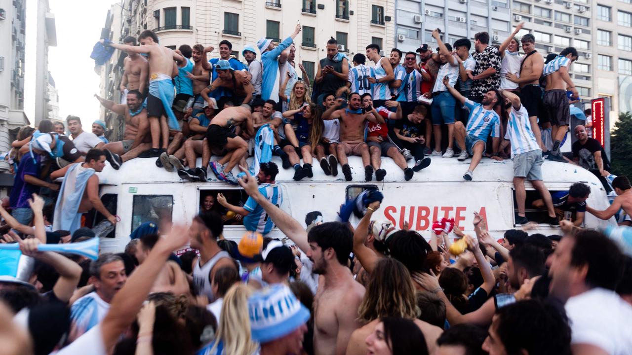 Fans of Argentina celebrate winning the Qatar 2022 World Cup against France at the Obelisk in Buenos Aires.)
