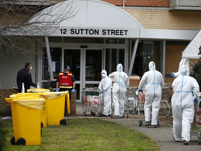 Workers in full body PPE deliver food into the locked down public housing towers in North Melbourne, Thursday, July 9, 2020. Photo: Daniel Pockett