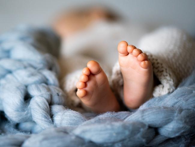 Foot of newborn baby on warm blanket