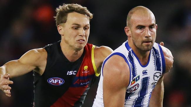 Dylan Clarke gets ready to wrap up North Melbourne’s Ben Cunnington. Picture: Michael Dodge/Getty Images.