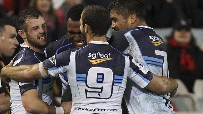 Brumbies players celebrate a try by outside centre Tevita Kuridrani.