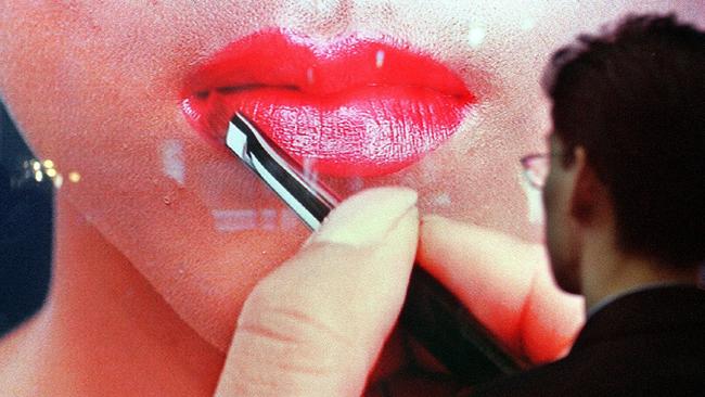 A man watches make-up applied to a woman’s lips. Picture: Supplied