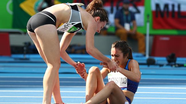 Abbey D'Agostino of the United States (R) is assisted by Nikki Hamblin of New Zealand.