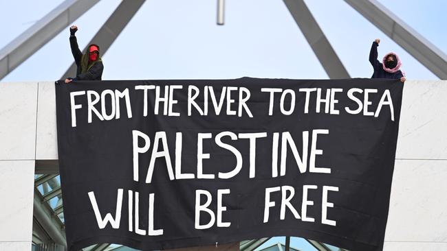 Pro-Palestine protesters unfurl a banner on the roof of Parliament House. Picture: NewsWire/Martin Ollman