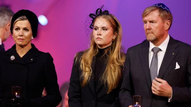 The Netherlands royals – Queen Maxima, Princess Catharina-Amalia and King Willem-Alexander – place votive candles in front of the train car, the symbol of the event, to pay tribute to the victims at Auschwitz-Birkenau. Picture: AFP