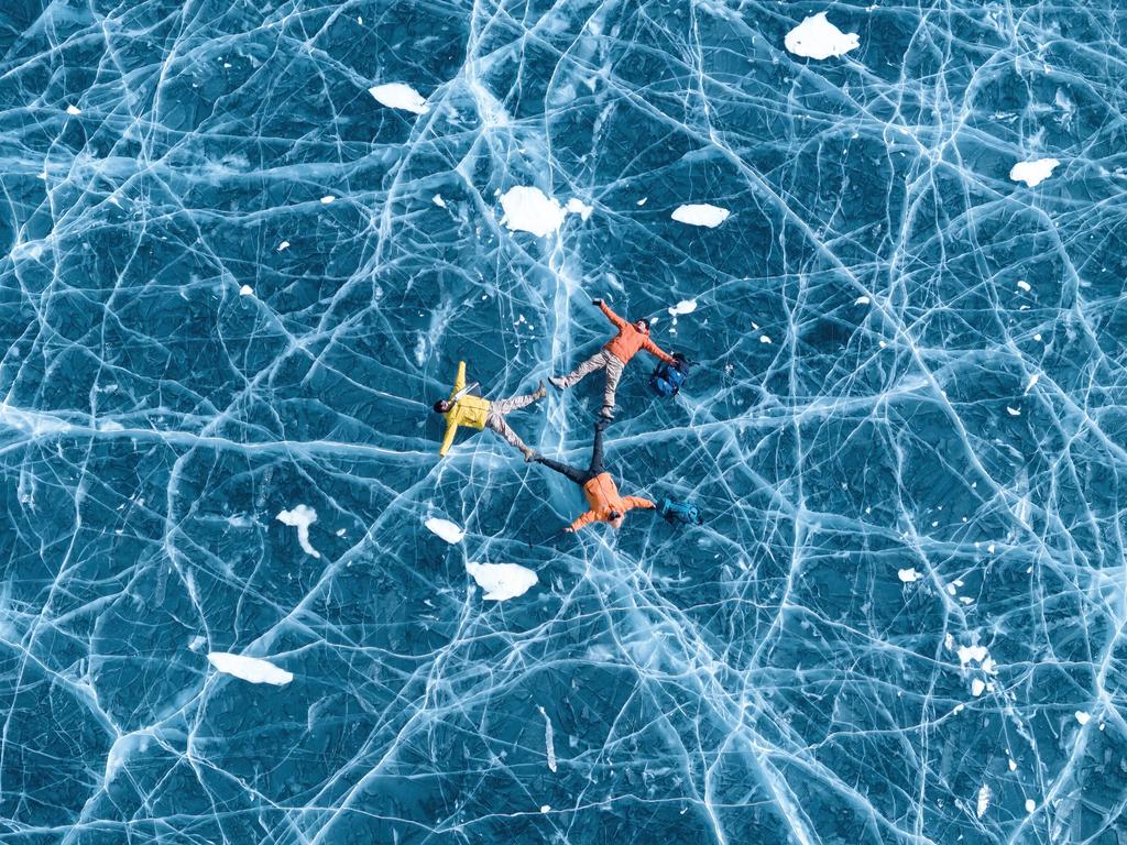 Tourists relax on the frozen expanse of Pumoyum Co Lake in Lhoka, Tibet, showcasing its crystal blue ice. Picture: Zhang Zhenqi/Getty Images