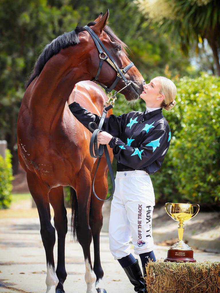 Jamie Kah keeps the Melbourne Cup at arm’s length while posing with race hopeful Okita Soushi. Picture: Rebecca Michael