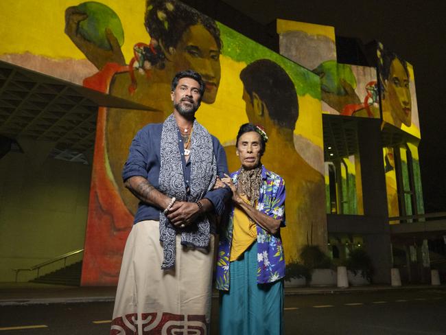 Tahiarii Yoram Pariente, of Raiatea in the Society Islands, and his mother Hélene Lee Tin outside the National Gallery of Australia, illuminated with Gauguin’s paintings. Picture: Martin Ollman