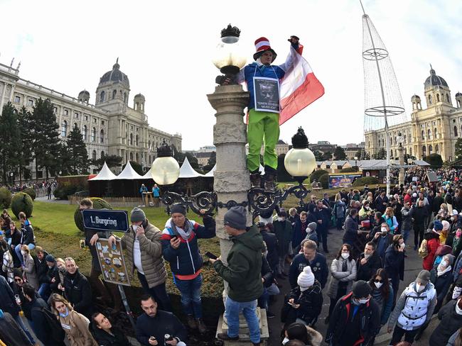 A demonstrator stands on a lamp post during a rally held by Austria's far-right Freedom Party FPOe against the measures taken to kerb Covid-19. Picture: AFP