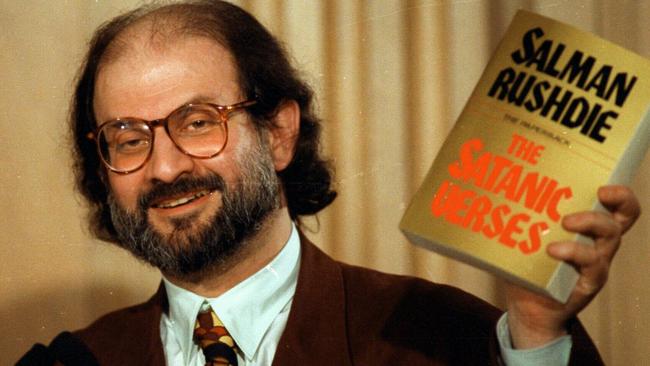 Salman Rushdie holds up a copy of <i>The Satanic Verses</i> during a 1992 news conference in Virginia.