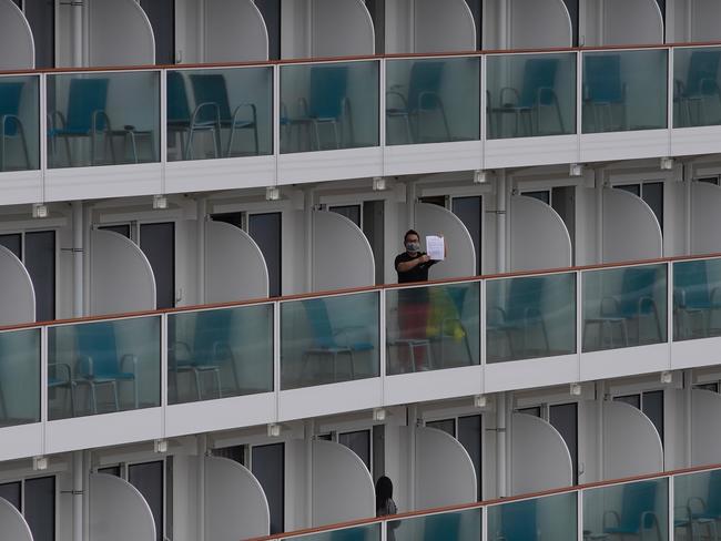 A passenger shows a note from the World Dream cruise ship docked at Kai Tak cruise terminal in Hong Kong. Picture: AP