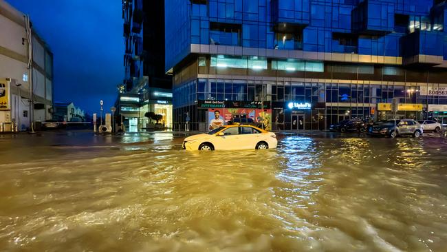 A taxi drives through a flooded street following heavy rains in Dubai. Picture: Giuseppe Cacace / AFP