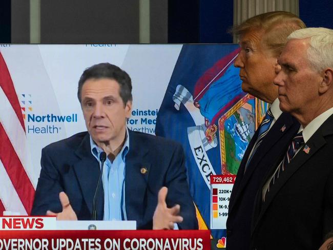 US President Donald Trump and US Vice President Mike Pence look on as a video plays of New York Governor Andrew Cuomo giving a press conference in an earlier breifing during a Coronavirus Task Force press briefing at the White House in Washington, DC, on April 19, 2020. (Photo by JIM WATSON / AFP)
